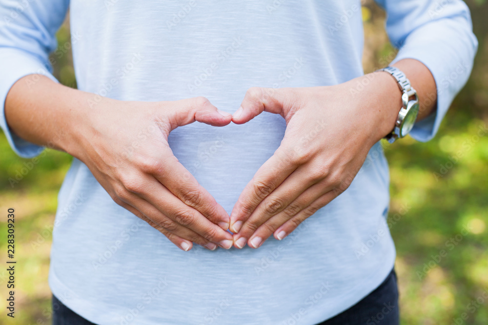 Hands forming heart over stomach for weight and metabolic wellness